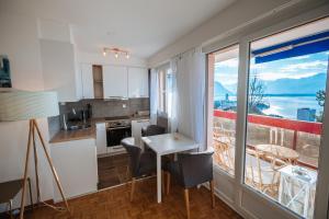 a kitchen and dining room with a view of the ocean at Terrace with Lake & Mountain View in Montreux