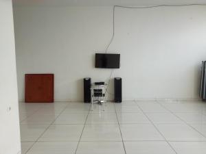 a white room with a table and a television on a wall at Villa batu malang panderman hill in Batu