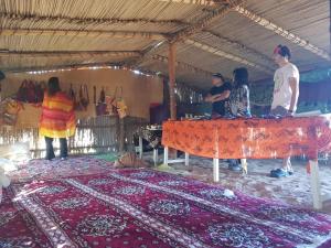 a group of people standing around a table with a rug at Home X4 in Al Wāşil