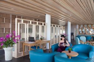 a woman sitting on a couch in a room at Diamond Cliff Resort & Spa - SHA Extra Plus in Patong Beach