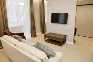 a living room with a white couch and a tv at TELEGRAPH INN in Petropavlovsk