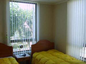 a bedroom with a bed and a large window at Departamento Viña del Mar in Viña del Mar