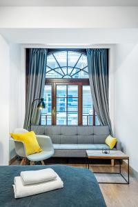 een woonkamer met een bank en een raam bij Gold Apartments Your Holiday Home in Krynica Zdrój