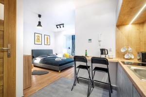 een kamer met een bed en een keuken met twee stoelen bij Gold Apartments Your Holiday Home in Krynica Zdrój