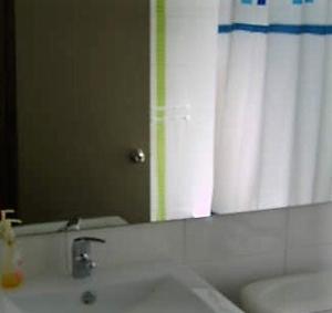 a bathroom with a white sink and a mirror at Departamento Viña del Mar in Viña del Mar +6 photos