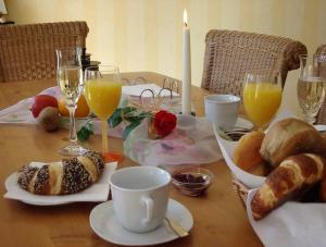 Gästehaus Alt Mehring في ميهرينغ: طاولة مع الخبز وكؤوس من عصير البرتقال