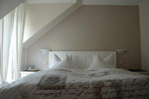 ein weißes Bett mit weißen Kissen und einem Fenster in der Unterkunft Gästehaus Alt Mehring in Mehring