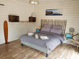 a bedroom with a bed with two towels on it at Au Bois Flotté in Hourtin
