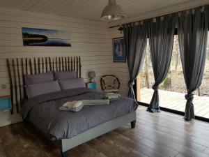 a bedroom with a bed and a large window at Au Bois Flotté in Hourtin
