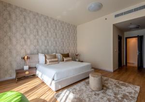 a bedroom with a large white bed and a rug at Peaks Apartments Dubai Marina in Dubai