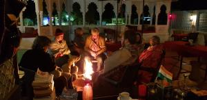 a group of people sitting around a fire in a room at Hotel Bundi House in Būndi