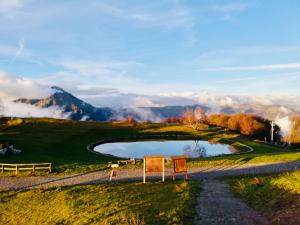a golf course in the mountains with a pond at Il Roccolino in Valsecca