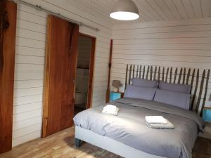a bedroom with a bed with two towels on it at Au Bois Flotté in Hourtin
