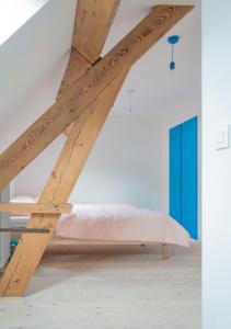 een bed in een kamer met houten balken bij De Vakantieschuur in Sint-Laureins