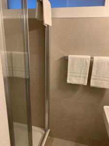 a bathroom with a shower and a sink and towels at Eh!Toi Self Motel in Etoy