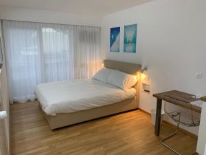 a small bedroom with a bed and a desk at Eh!Toi Self Motel in Etoy