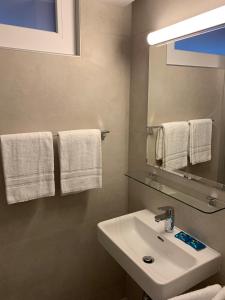 W łazience znajduje się umywalka, lustro i ręczniki. w obiekcie Eh!Toi Self Motel w mieście Etoy