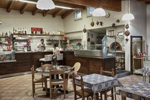 a restaurant with tables and chairs and a chef in the kitchen at Villaggio Camping Valdeiva in Deiva Marina