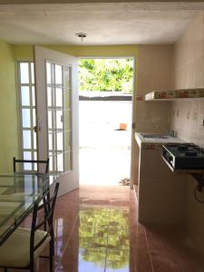 une cuisine avec une table en verre et une porte de garage blanche. dans l'établissement Apartamento Colonial Campeche, à Campeche