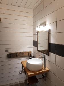 a bathroom with a white sink and a mirror at Au Bois Flotté in Hourtin