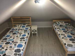 two twin beds in a room with a attic at Apartamenty Baltyk in Karwia