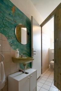 ein Bad mit einem Waschbecken und einem Spiegel in der Unterkunft Hostel Aachen in Aachen