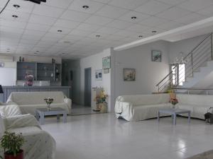 a large living room with couches and a staircase at Megim Hotel in Palaiochora