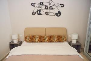 a bed with a cheetah print pillow and two lamps at המקום של אורלי in Eilat