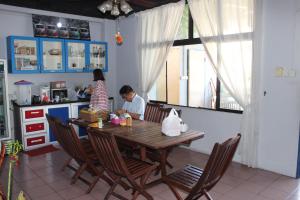
a man and a woman sitting at a table in a kitchen at The Jesselton Cabin Sdn Bhd in Kota Kinabalu
