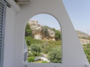 an arch window with a view of a mountain at Megim Hotel in Palaiochora