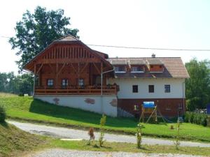 uma casa grande com um telhado de gambrel numa colina em Őrszem Fogadó em Szalafő