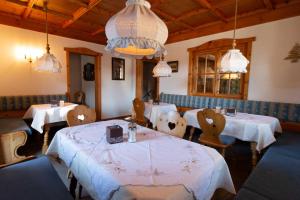 a dining room with tables and chairs and lights at Kur- und Ferienhotel Haser in Oberstaufen
