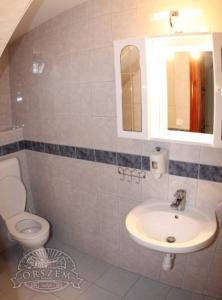 La salle de bains est pourvue d'un lavabo et de toilettes. dans l'établissement Őrszem Fogadó, à Szalafő