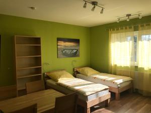 Grünes Zimmer mit 2 Betten und einem Fenster in der Unterkunft Ferienwohnung Mayer in Rangsdorf