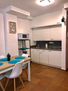 a kitchen with a wooden table and white cabinets at Maribel Arttyco in Sierra Nevada