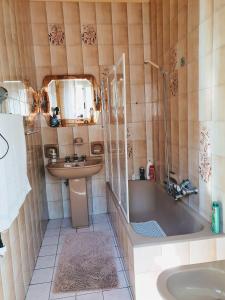 een badkamer met een bad, een wastafel en een douche bij 24 Cannoli in Leonforte
