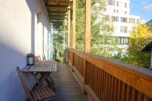 a porch with a bench and a table on a balcony at Schwarzacherhof Pension & Apartments in Schwarzach im Pongau