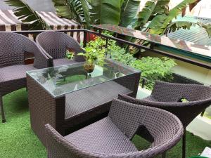 une table et des chaises en verre sur un balcon orné de plantes dans l'établissement Ventana house, à Hai Phong
