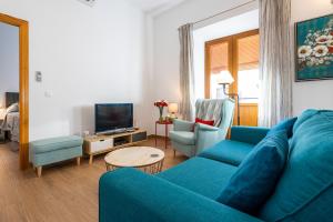 sala de estar con sofá azul y 2 sillas en Carrasco 4, en Vélez-Málaga