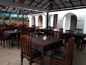 a restaurant with black tables and chairs at Rudraksha Holiday Homes in Candolim
