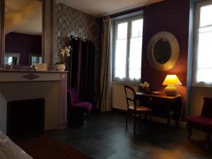 een woonkamer met een open haard en een tafel en stoelen bij Chambres d'Hôtes La Toast Vin in Saint-Sever