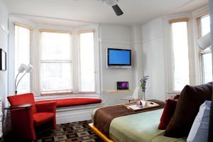 a bedroom with a bed and a chair and a tv at The Mosser Hotel in San Francisco