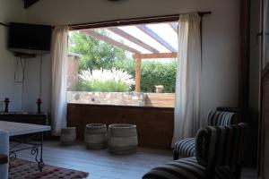 a living room with a window and a table and chairs at Casa El Drago in La Cumbre