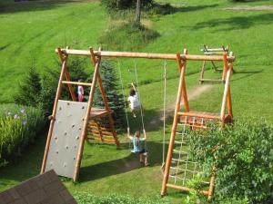 a group of people on a swing set in a yard at U Sadílků in Paseky nad Jizerou