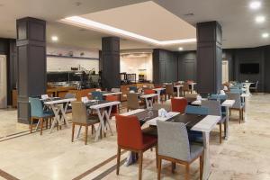a restaurant with tables and chairs and a kitchen at Seckin Hotel in Sakarya