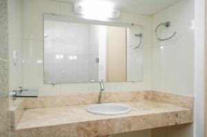 a bathroom with a sink and a mirror at Hotel Villaverde in Adamantina