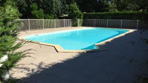 a swimming pool in a yard with a fence at Apartment Cap Meyran in Gujan-Mestras
