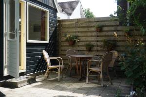 a patio with a table and chairs next to a building at B&B Waterland in Middelie