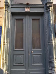 a blue door on a building with a sign above it at Connection Guesthouse in Budapest