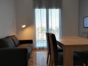 uma sala de estar com uma mesa e um sofá em Apartments Granzola em Sukošan